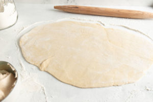 using a rolling pin to roll out the dough