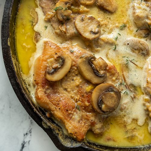 close up of smothered pork chops in cast iron skillet