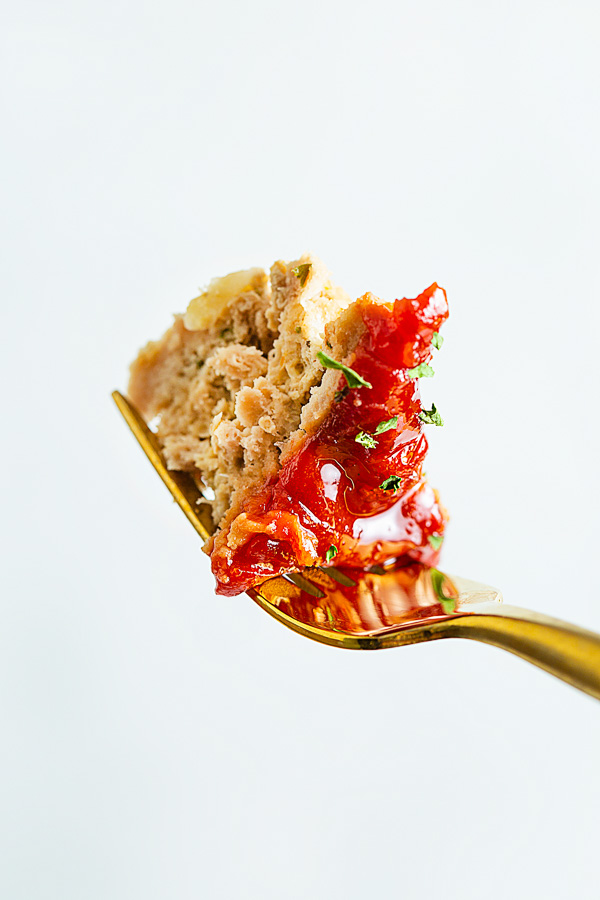 A close up fork image of ground turkey meatloaf with spicy ketchup glaze