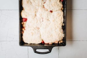 Overhead image of rhubarb cobbler in a cast iron casserole dish.