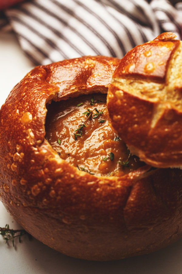 Close up image of butternut squash soup with apple in a bread bowl. 