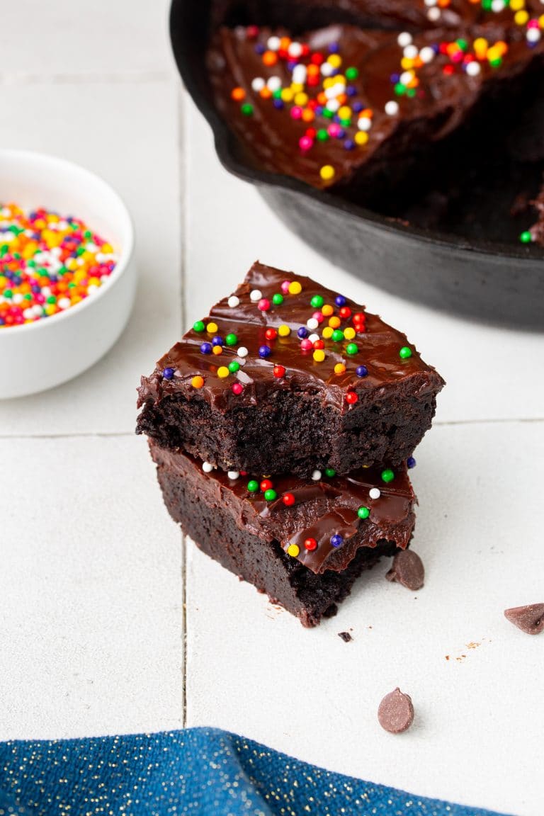 Cosmic brownies stacked in front of a cast iron skillet