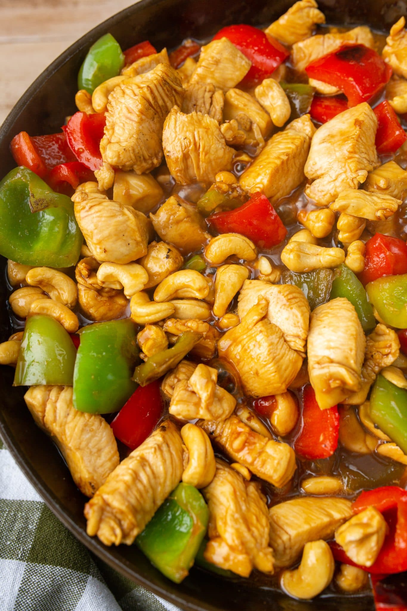close up of chicken with cashew nuts being cooked in a large skillet