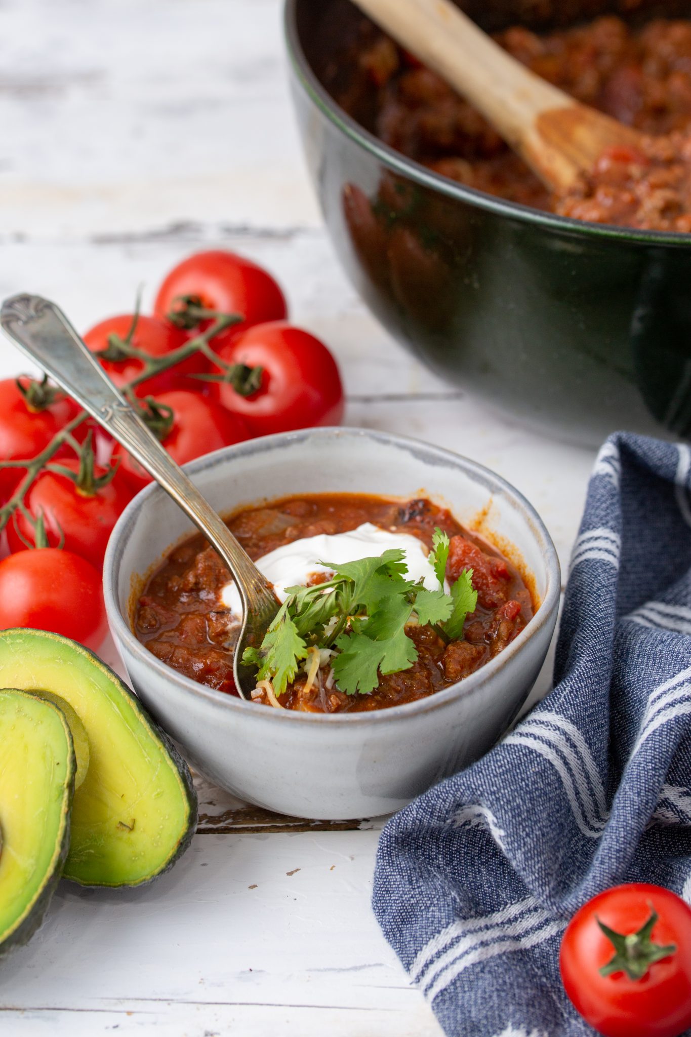 dutch oven baked bean chili topped with sour cream and cilantro