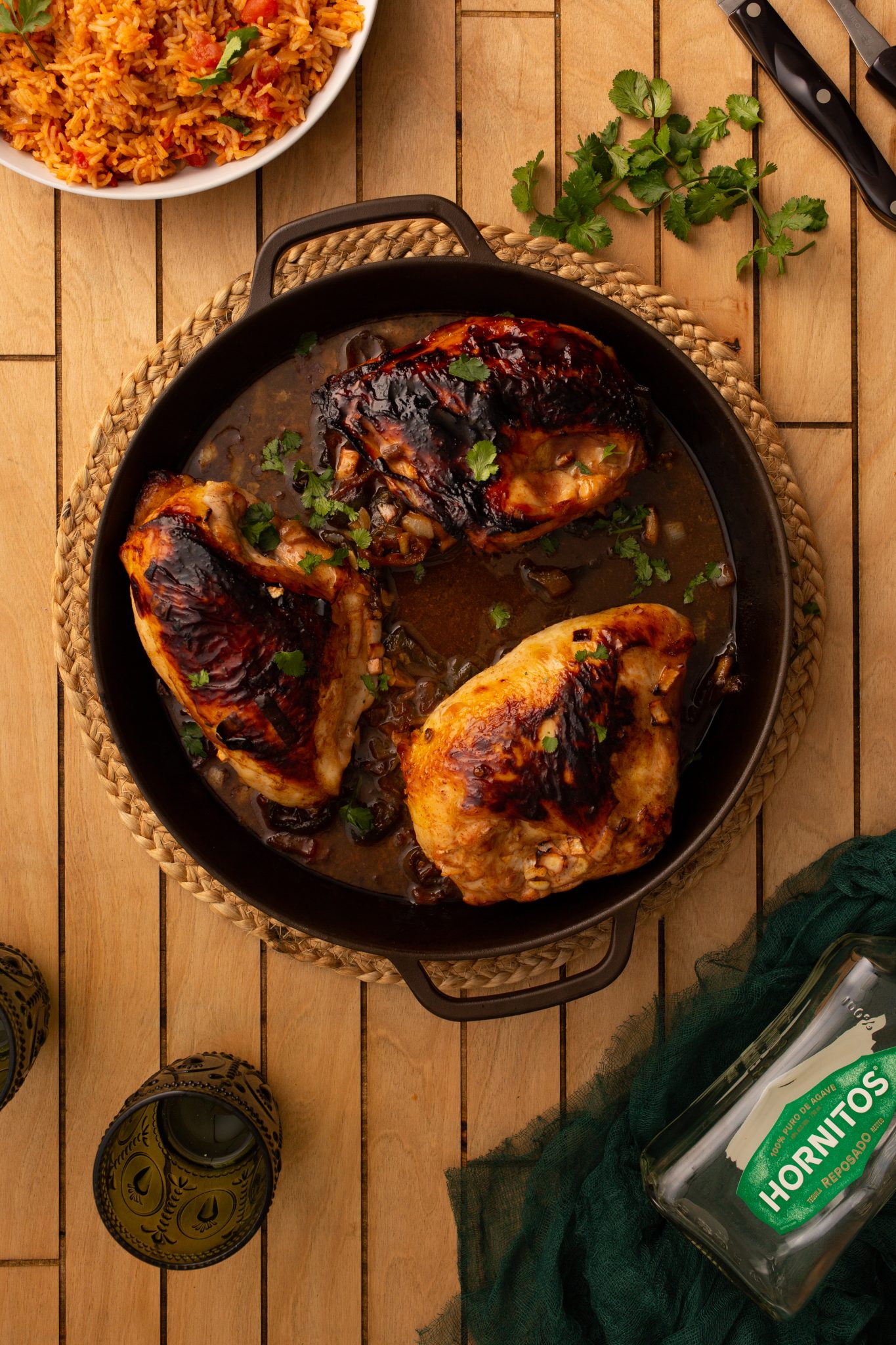 Chipotle Lime Chicken Leg Quarters in a braising cast iron skillet topped with cilantro