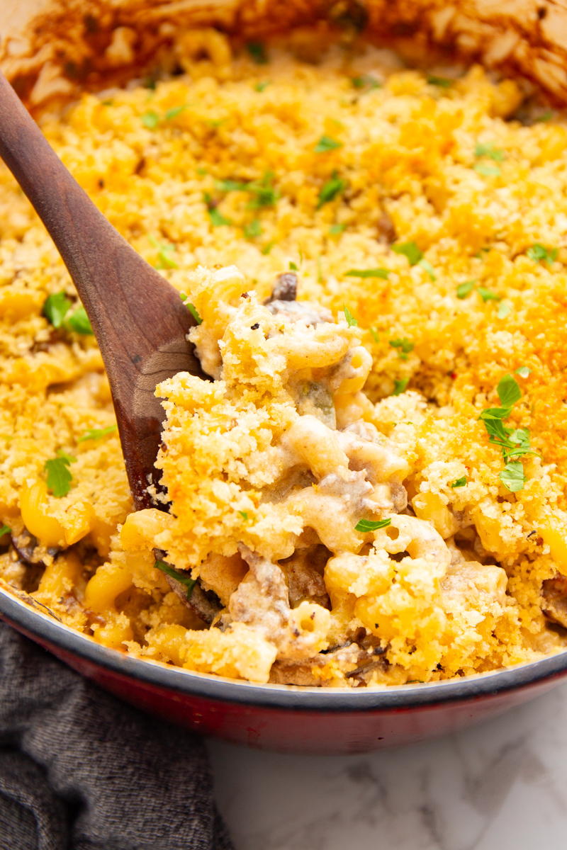 cheesesteak mac and cheese close up in a dutch oven with bread crumb topping